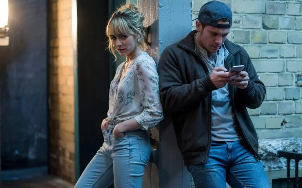 Blonde woman standing next to shady man on phone